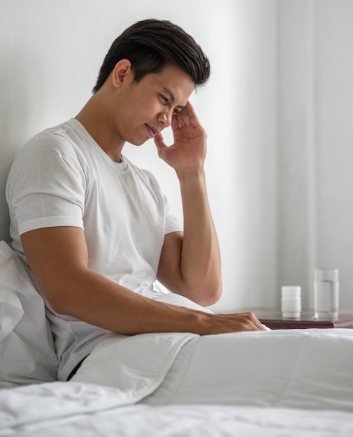 Le malade s'assit sur le lit, touchant sa tête avec sa main.