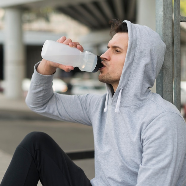 Photo gratuite mâle adulte de l'eau potable après l'exercice