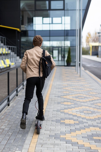 Mâle adulte monté sur un scooter électrique