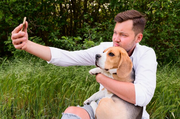 Mâle adulte prenant un selfie avec chien mignon