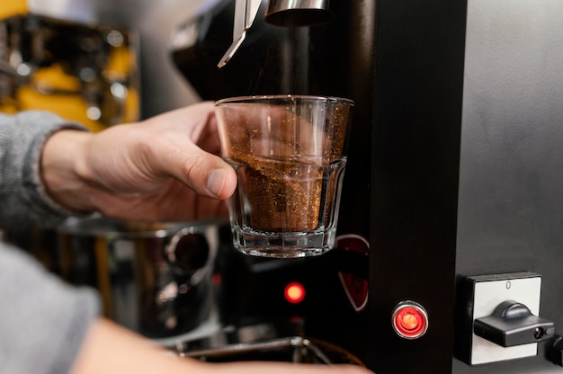 Mâle barista moudre le café avec machine