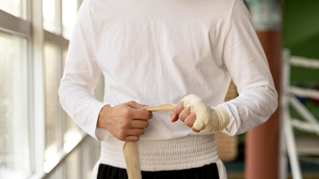 Male boxer enveloppant ses mains avec un cordon de protection