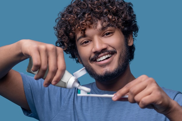 Photo gratuite mâle joyeux regardant la caméra avant la procédure de brossage des dents