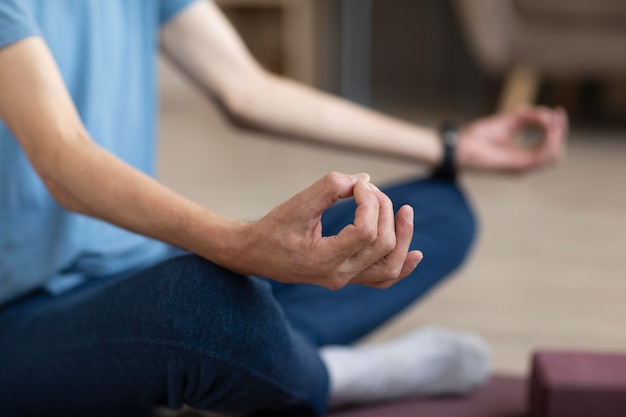 Mâle occasionnel pratiquant le yoga à la maison