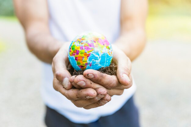 Mâles mains tenant un petit globe