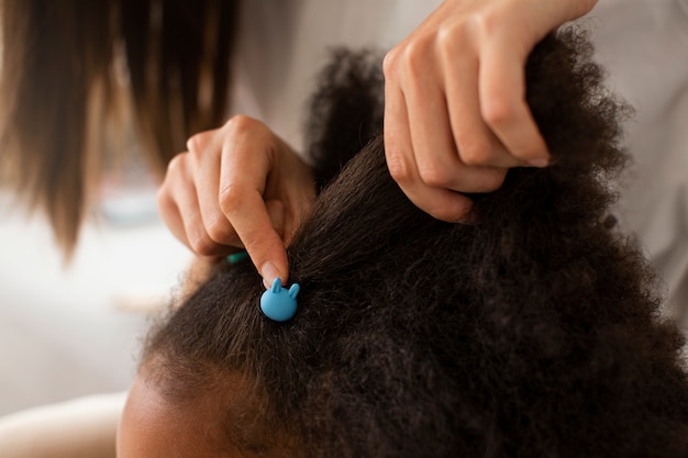 Photo gratuite maman aidant son enfant à coiffer les cheveux afro
