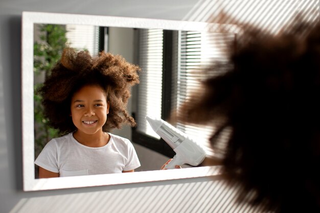 Maman aidant son enfant à coiffer les cheveux afro