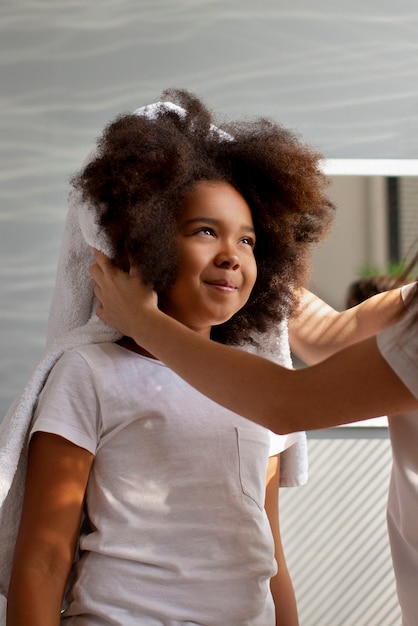 Maman aidant son enfant à coiffer les cheveux afro