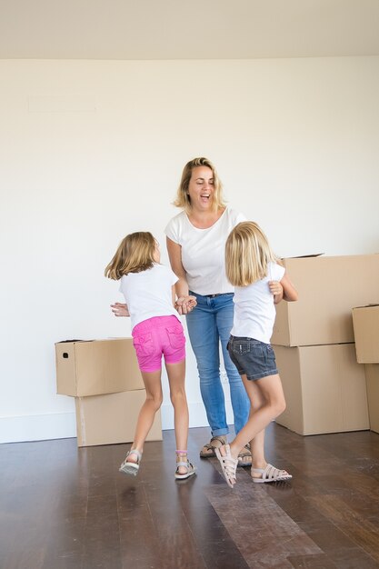 Maman caucasienne ravie de jouer avec deux filles et de rire