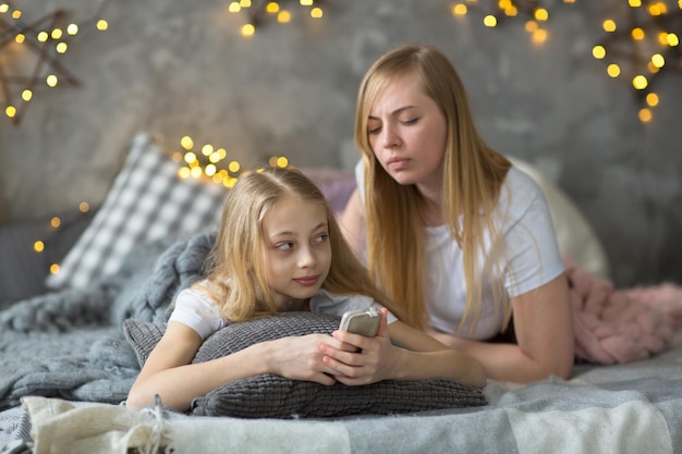 Maman et enfant blond adolescent et smartphone