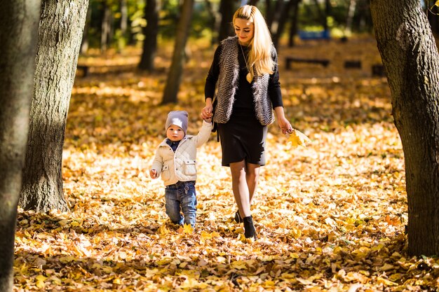 Maman et fils marchant dans un parc d'automne