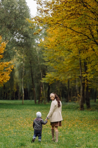 Maman et fils marchant et s'amusant ensemble dans le parc d'automne.