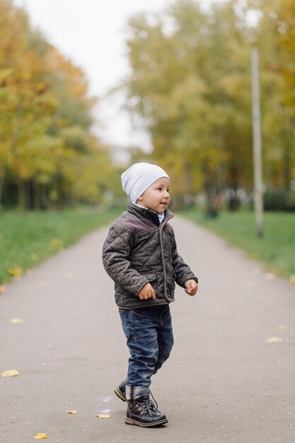 Maman et fils marchant et s'amusant ensemble dans le parc d'automne.