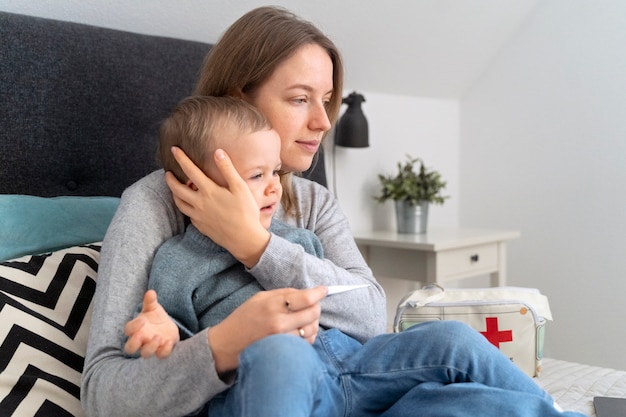 Maman prenant soin de son enfant et téléconsultation avec un médecin