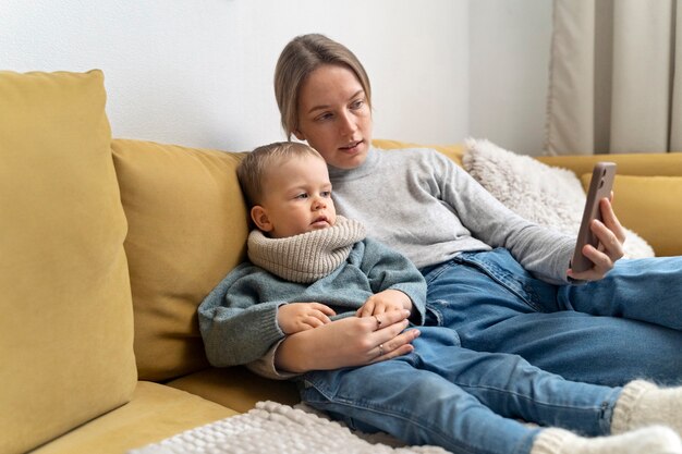 Maman prenant soin de son enfant et téléconsultation avec un médecin