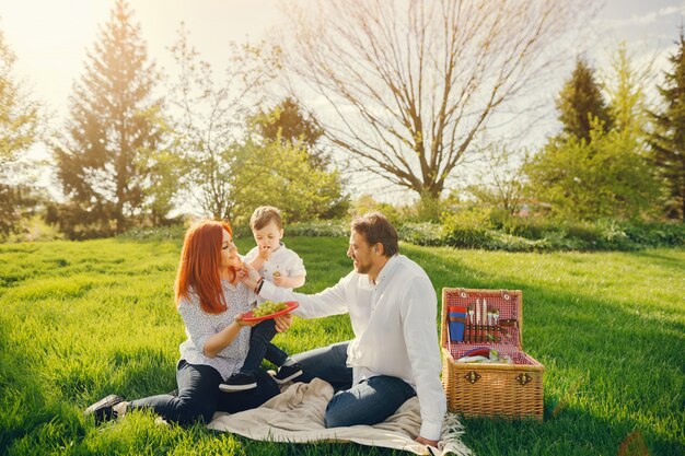 maman rousse belle et élégante dans un chemisier blanc est assis sur l&#39;herbe avec son bel homme