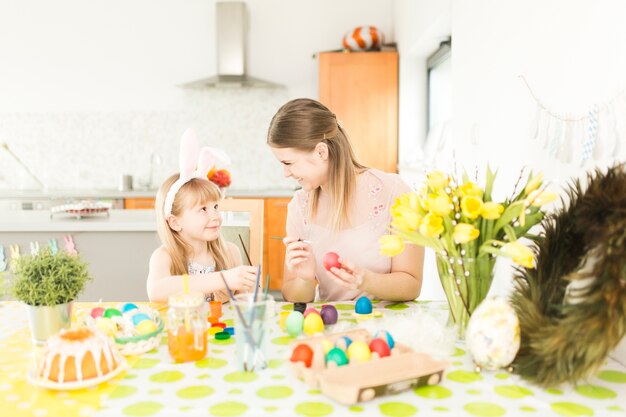 Maman et sa fille décorer des oeufs de Pâques traditionnels