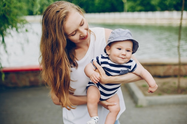 Photo gratuite maman et son fils se détendent dans le parc et se promènent autour de la rivière.