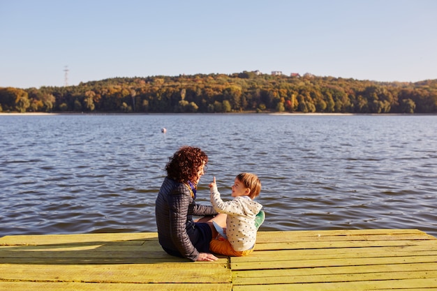 Maman et son fils se reposant au bord du lac