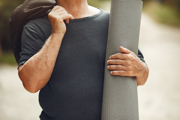 Man au parc d'été. Grangfather avec un tapis.