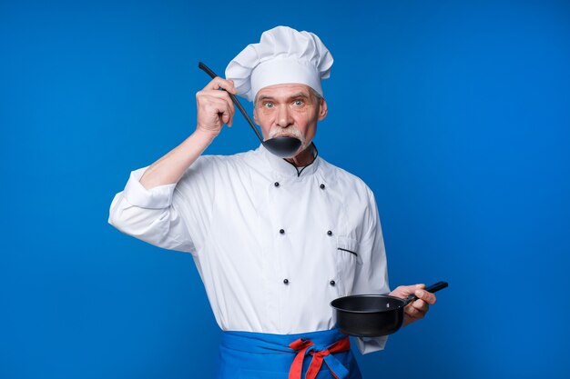 Man avec barbe cuisinier avec visage excité en uniforme avec louche