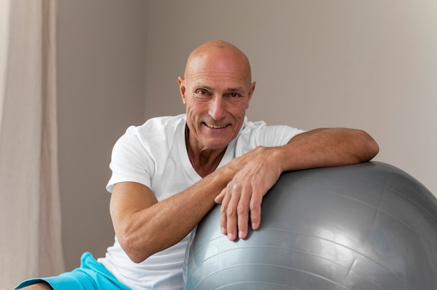 Photo gratuite man faire des exercices avec ballon de fitness