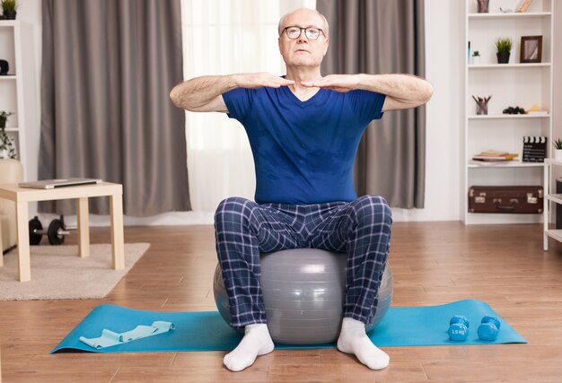 Man formation sur ballon de stabilité dans le salon