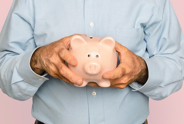 Man holding piggy bank pour la campagne d'épargne financière