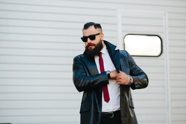 Man en imperméable en cuir de mettre quelque chose dans sa poche intérieure