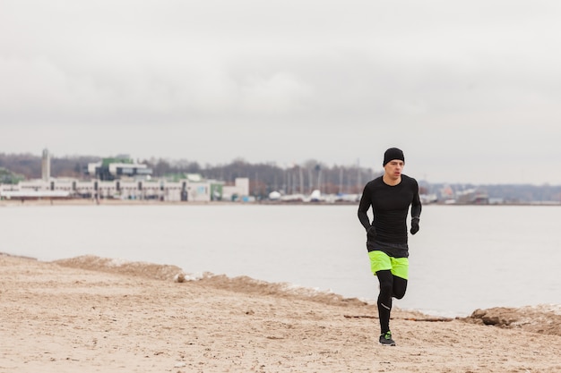 Photo gratuite man jogging sur la plage