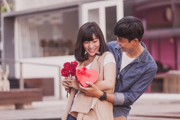 Man remettre un cadeau et des roses à une femme