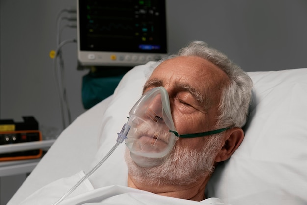 Man avec respirateur dans un lit d'hôpital