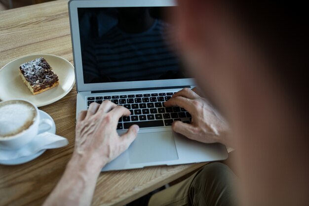 Man utilisant un ordinateur portable dans le café