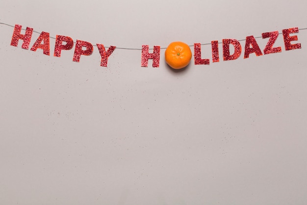 Photo gratuite mandarine sur l'écriture de happy holidaze