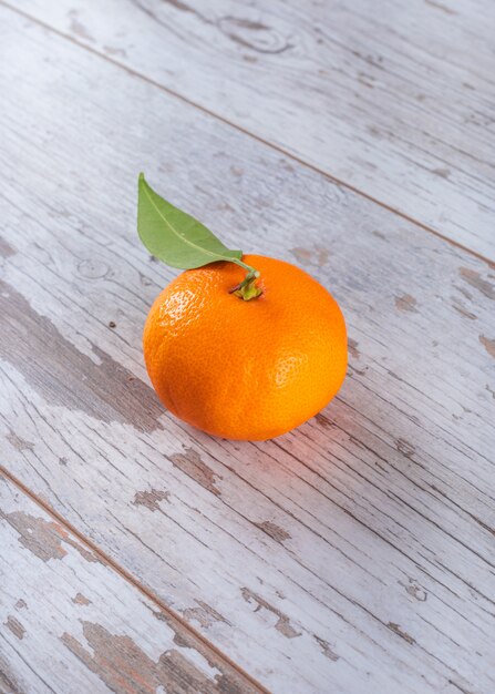Mandarine fraîche avec des feuilles sur une table en bois