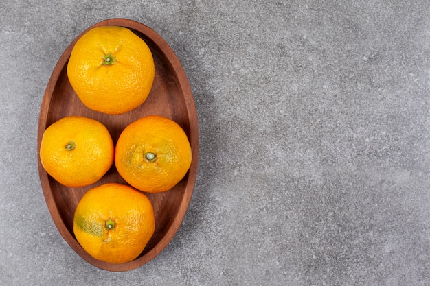 Photo gratuite mandarines sucrées fraîches sur une planche de cuisine en bois