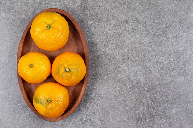 Mandarines sucrées fraîches sur une planche de cuisine en bois