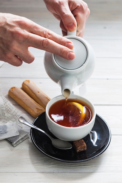 Manger les mains avec une tasse de thé
