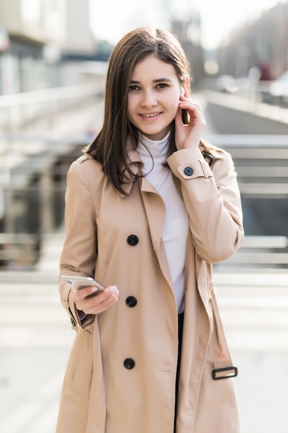 Une mannequin brune met ses écouteurs sans fil pendant un appel vidéo