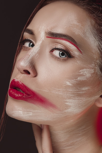 Mannequin femme au visage coloré peint. Portrait d'art beauté mode de belle femme avec du maquillage abstrait coloré.