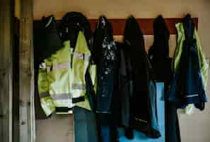 Photo gratuite manteaux et vestes de travail suspendus à une étagère