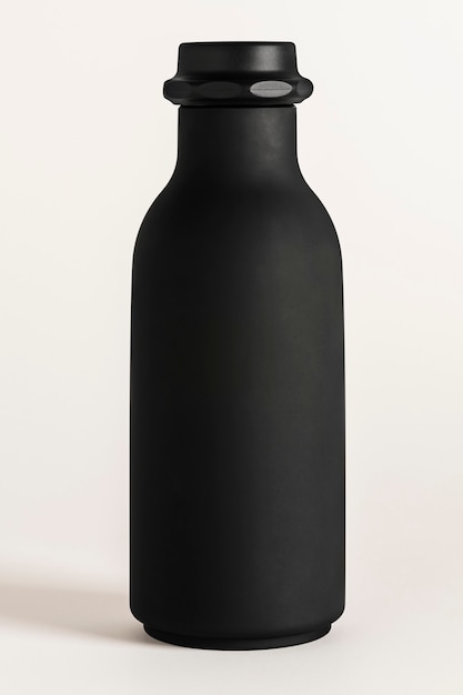 Maquette de bouteille d'eau noire sur fond blanc cassé