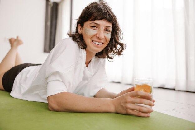 Maquette de patchs cosmétiques pour les yeux en hydrogel pour femme à la maison avec de l'eau en verre