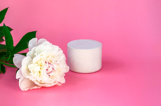Maquette de podium blanc vide avec pivoine blanche sur fond pastel rose se bouchent