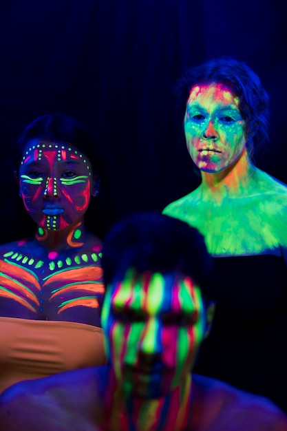 Maquillage fluorescent coloré sur les femmes et les hommes