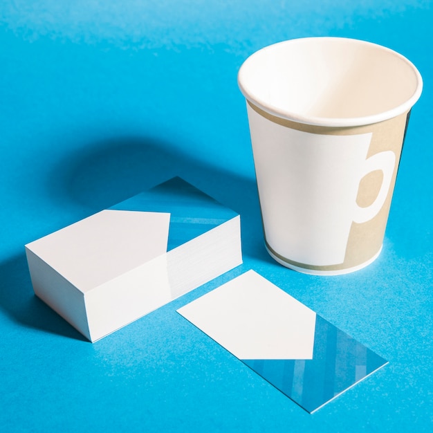 Photo gratuite maquillage de papeterie avec pile de cartes de visite et de tasse