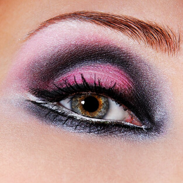 Maquillage des yeux noir-violet. Yeux verts. Macro une photo d'un œil.