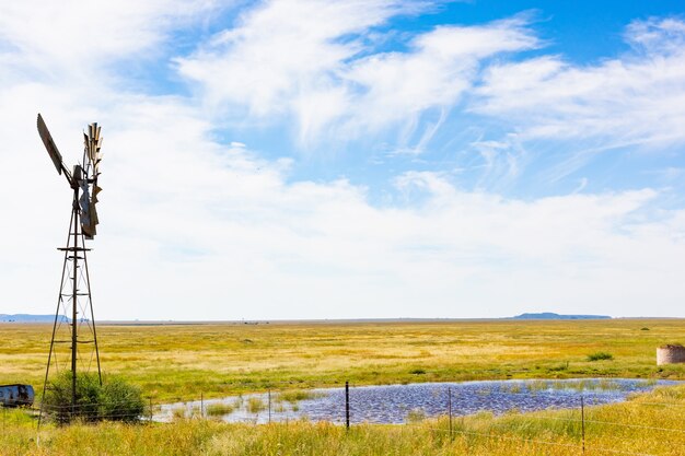 Marais et une éolienne sous le ciel nuageux en Afrique du Sud