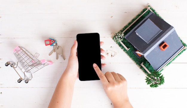 Marché immobilier avec clés de la maison, caddie et téléphone