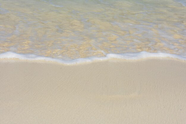 Marée descendant loin du rivage couvert de sable